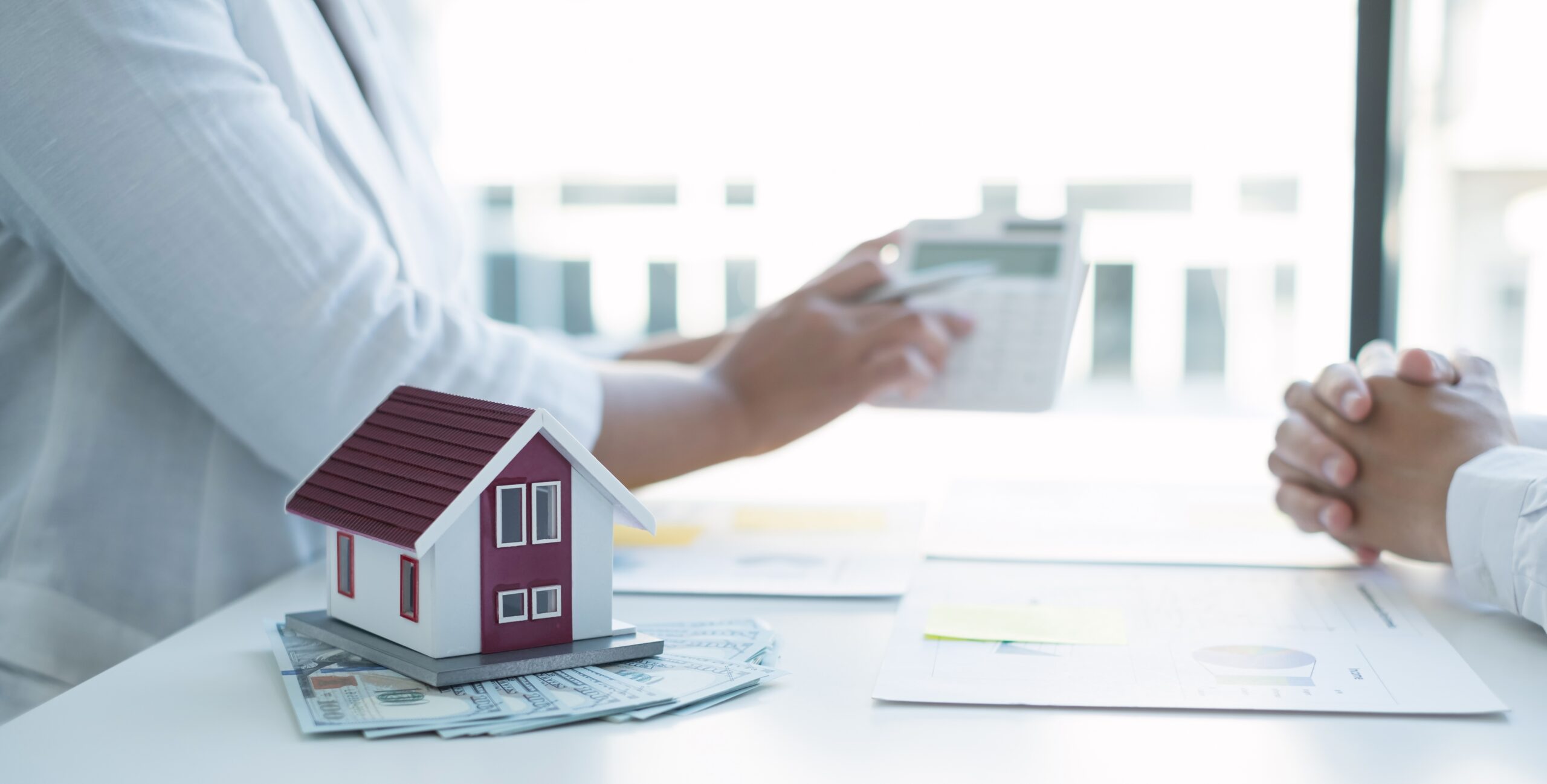 house on white desk with money